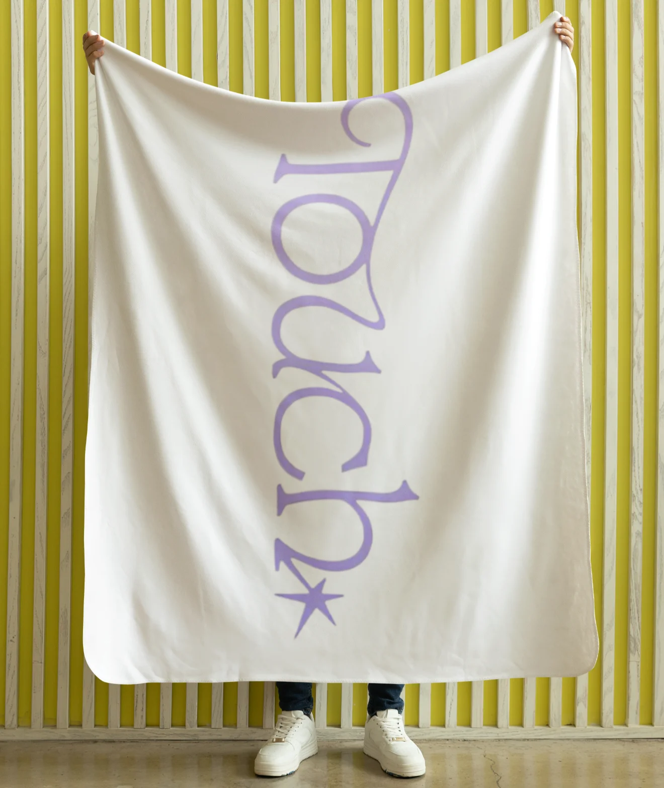 model holding white katseye blanket with touch purple design